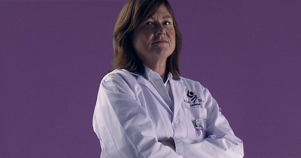 Janice Robertson, leading Canadian ALS researcher, in a white lab coat, arms crossed.