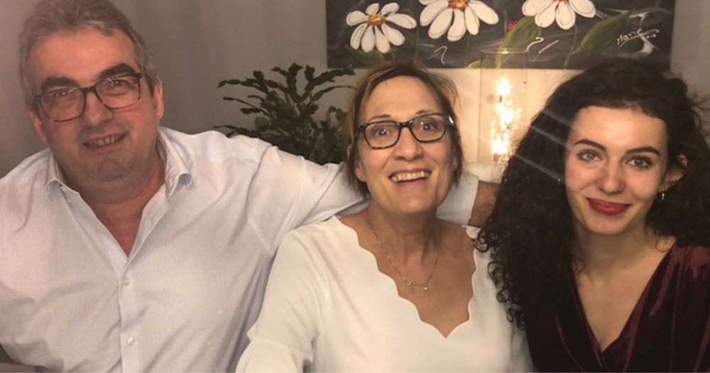 Catherine Brassard with two family members, all smiling together at home.